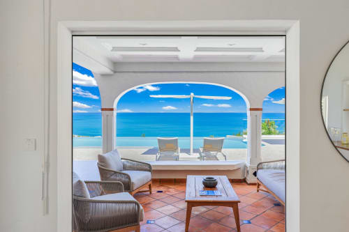 Terrasse face à mer de Villa Agama à Saint-Martin avec transats, piscine à débordement et vue sur l'océan azur