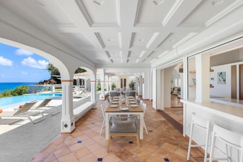 Salle à manger de la Villa Agama avec vue sur l'océan, terrasse et piscine dominant Saint-Martin