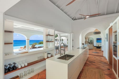 Cuisine moderne avec vue sur l'océan à la Villa Agama, Saint-Martin, carrelage en terre cuite et mobilier blanc