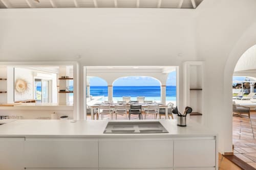 Cuisine moderne avec vue océan à la Villa Agama, Saint-Martin, surplombant l'espace repas en bord de mer