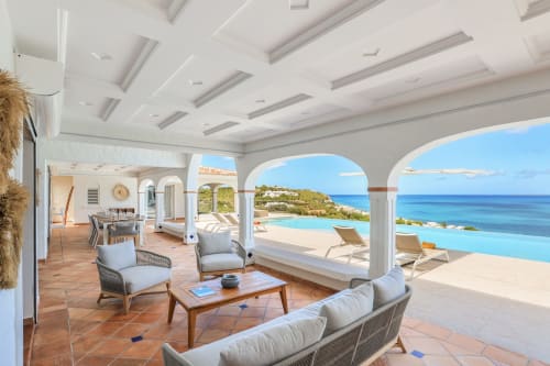 Terrasse luxueuse de la Villa Agama à Saint-Martin avec vue mer, piscine à débordement, mobilier moderne et style méditerranéen