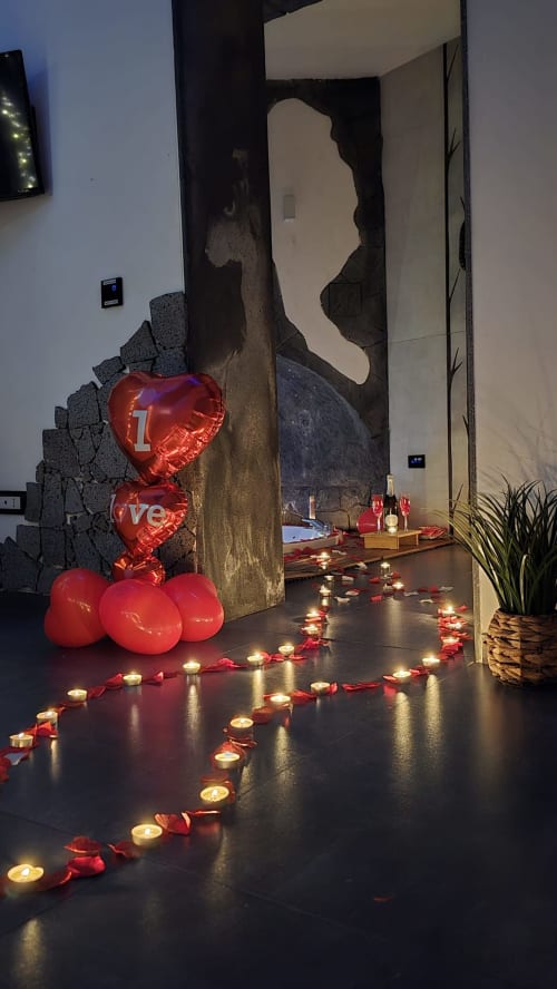 Atmosfera romantica della suite spa per San Valentino presso Elite Apartment SPA Catania con palloncini a forma di cuore, candele e petali di rosa