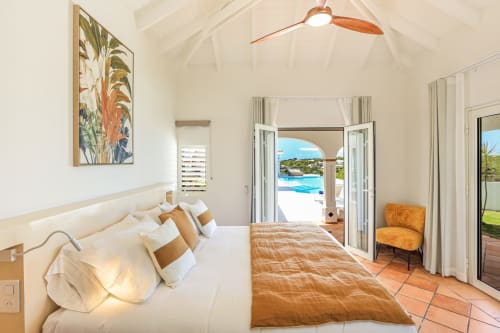 Chambre de luxe à la Villa Agama à Saint-Martin avec vue sur l'océan, ventilateur de plafond moderne et accès direct à la terrasse piscine