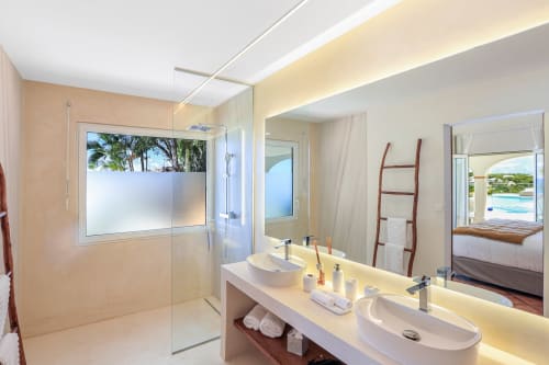 Salle de bains moderne et luxueuse à la Villa Agama Saint-Martin avec double vasque, douche à l'italienne et vue sur l'océan