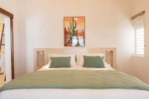 Chambre moderne à la Villa Agama avec coussins verts, tête de lit en bois et œuvres d'art de cactus du désert, Saint-Martin