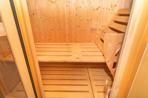 Vista interna della cabina sauna in legno della suite SPA Elite Apartment a Catania con panche riscaldate e rivestimento in cedro