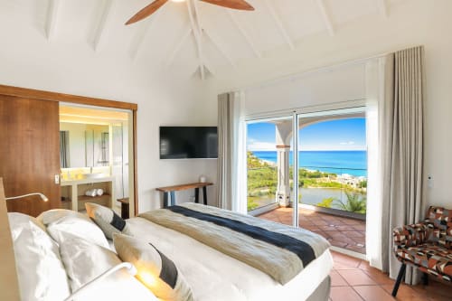 Chambre luxueuse à la Villa Agama à Saint-Martin avec vue océan, équipements modernes et accès à la terrasse en bord de mer
