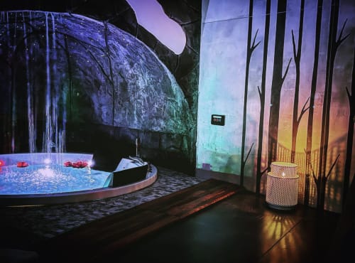 Suite SPA di lusso a Catania con vasca idromassaggio illuminata, illuminazione ambientale e decorazioni murali a tema forestale