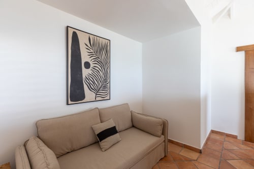 Canapé beige avec coussin noir dans la chambre d'hôtes de la Villa Agama, Saint-Martin