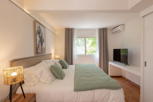 Chambre moderne à la Villa Agama, Saint-Martin avec lit queen-size, accents verts, TV écran plat et vue sur le jardin