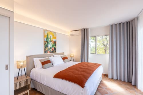 Chambre moderne et lumineuse à la Villa Agama Saint-Martin avec lit queen, touches terracotta et vue sur le jardin