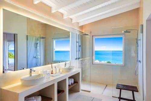 Salle de bain luxe face à l'océan à la Villa Agama, Saint-Martin, avec double vasque, douche à l'italienne et vue sur la mer turquoise