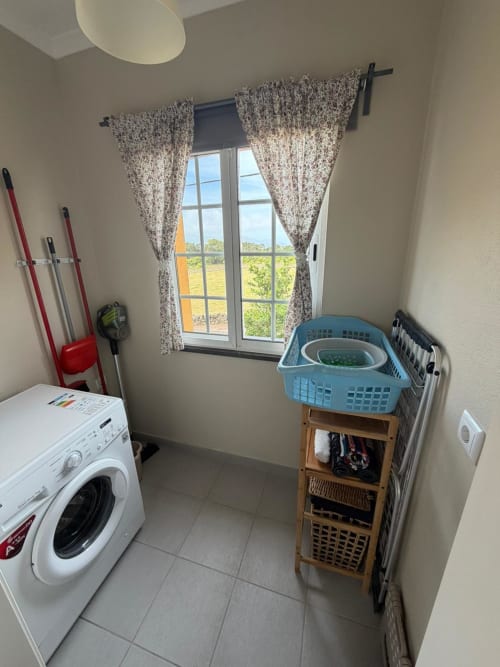 Laundry room at Casa da Avó Alice villa, Inn Nature, with washing machine, storage baskets, and countryside view