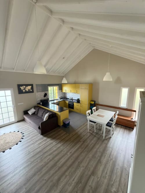 Casa da Avó Alice villa at Inn Nature in São Roque do Pico featuring yellow kitchen, dining area, living room with vaulted