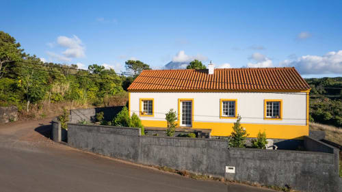 Casa da Avó Alice villa at Inn Nature in São Roque do Pico with white and yellow exterior, terracotta roof
