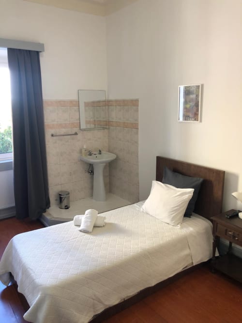 Quarto individual na Guest House Infante Dom Henrique em Coimbra com lavatório privado e acesso a casa de banho partilhada