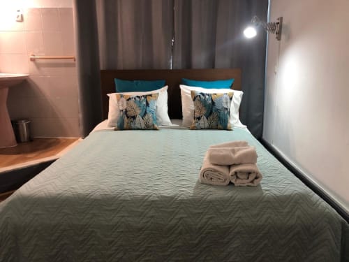 Quarto duplo moderno na Pousada Infante Dom Henrique em Coimbra com almofadas arrumadas e toalhas enroladas