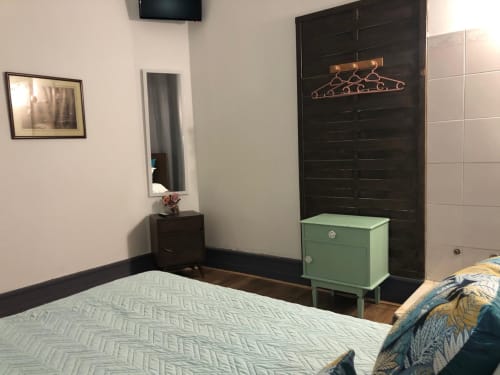 Aconchego do quarto de hotel da Guest House Infante Dom Henrique com cama, guarda-roupa escuro, criado verde e TV em Coimbra