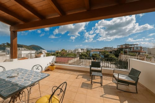 Ampia terrazza di Casa Giuliana e Malvasia 70 a Lipari con vista sul mare, tavolo da pranzo e sedute all'aperto