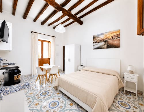 Appartamento Malvasia Passito a Casa Giuliana e Malvasia 70 a Lipari con letto, angolo cottura e pavimento in maiolica