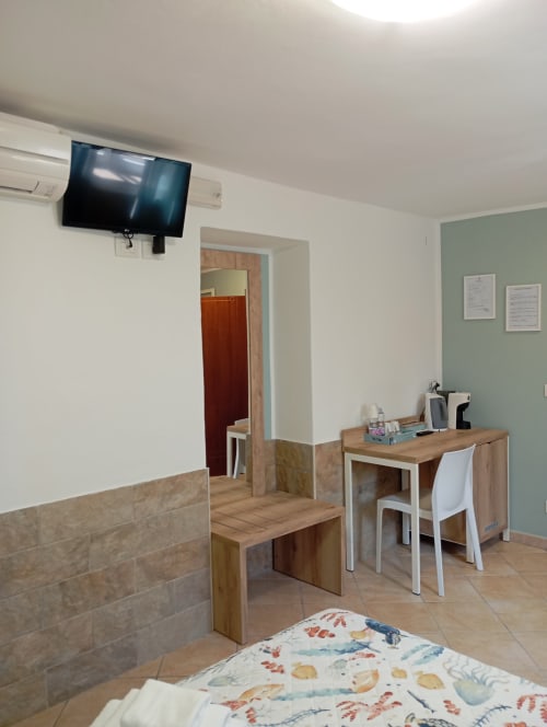 Camera luminosa a Roccabianca con letto, scrivania, TV e comfort moderni a Stintino