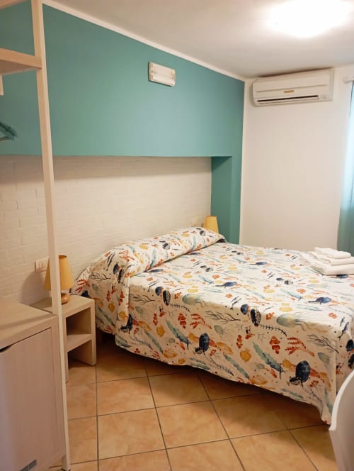 Camera matrimoniale a Roccabianca Rooms, Stintino con accenti turchesi, arredamenti moderni e aria condizionata