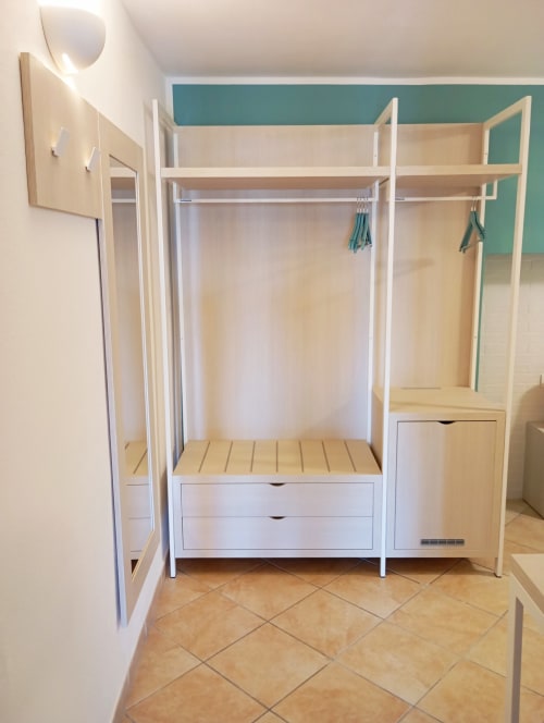 Sistema moderno di guardaroba nella camera doppia standard di Roccabianca Rooms, Stintino con ripiani in legno e soluzioni di stoccaggio