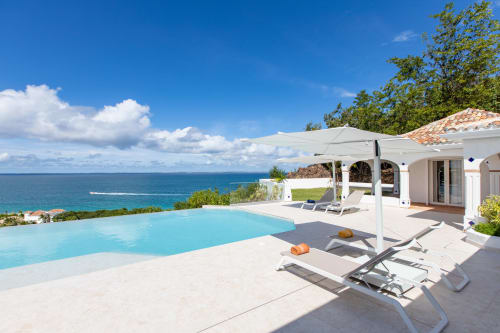 La piscine à débordement de la Villa Agama surplombant les eaux turquoise de la Caraïbe et le littoral tropical de Saint-Martin
