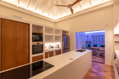 Cuisine moderne de la Villa Agama, Saint-Martin, avec plans de travail blancs, placards en bois et puits de lumière