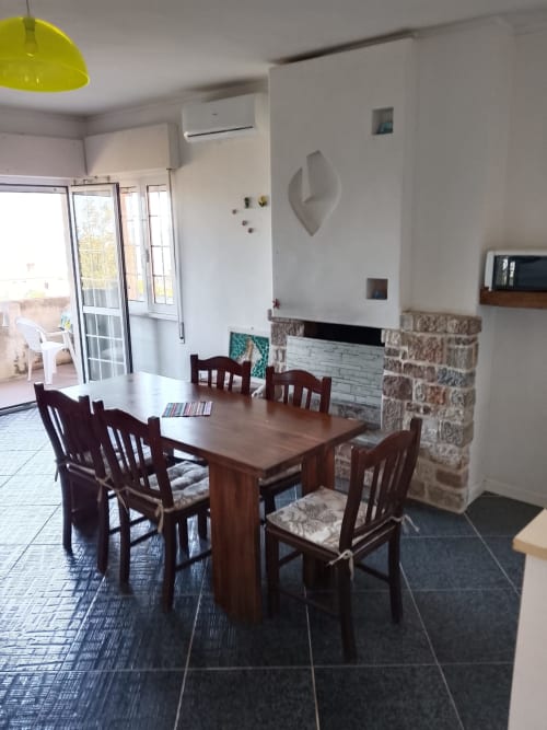 Zona pranzo con tavolo e sedie in legno nell'appartamento Brezza dei Trabocchi di Tales of Abruzzo, Atessa