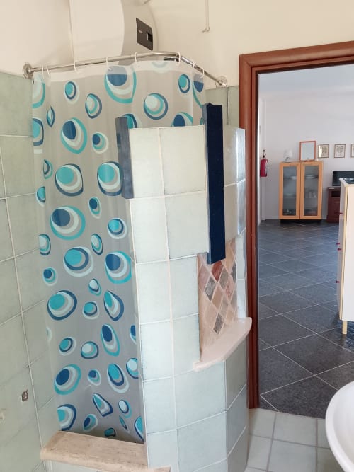 Bagno con doccia e tenda a motivi circolari turchesi nell'appartamento Tales of Abruzzo, Atessa Italia