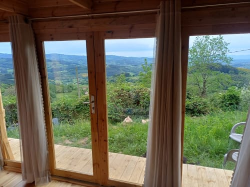 Mountain valley view from Le Grand Chêne room at La Maison de Dun BnB, Saint Racho, with wooden deck and green landscape