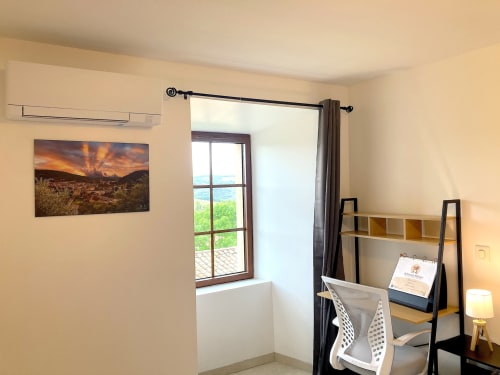 Habitación Le Châtelet en Au Château De Villelongue con vista al jardín, escritorio, estanterías y campiña verde visible