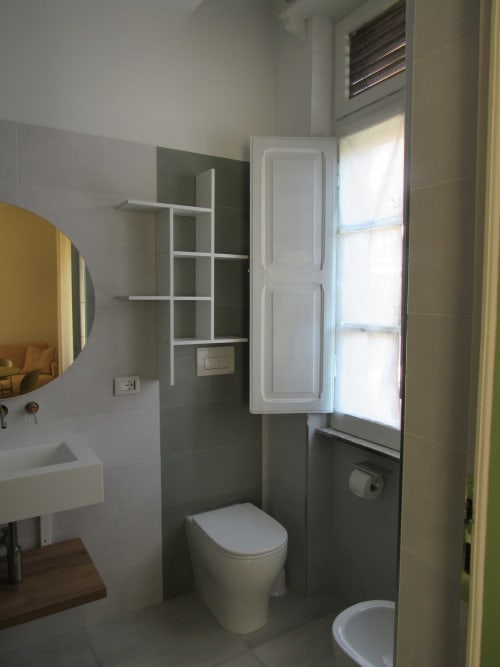 Bagno moderno in Camera More presso Il 900 B&B, Avezzano, con toilette, lavabo, specchio, finestra e mobile bianco contenitore