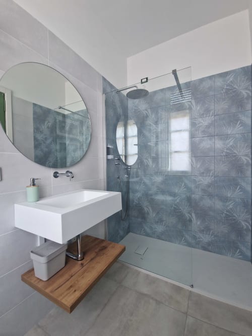 Bagno moderno nella Camera Camelie dell'Il 900 B&B ad Avezzano con specchio rotondo, lavabo bianco e doccia piastrellata