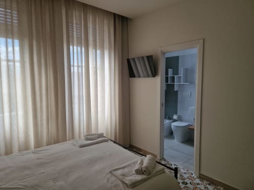 Camera moderna presso Il 900 B&B ad Avezzano con letto bianco, TV a parete e bagno ensuite
