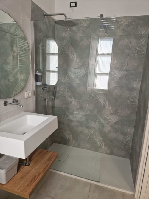 Bagno moderno presso Il 900 B&B ad Avezzano con cabina doccia, lavabo bianco e mobile in legno