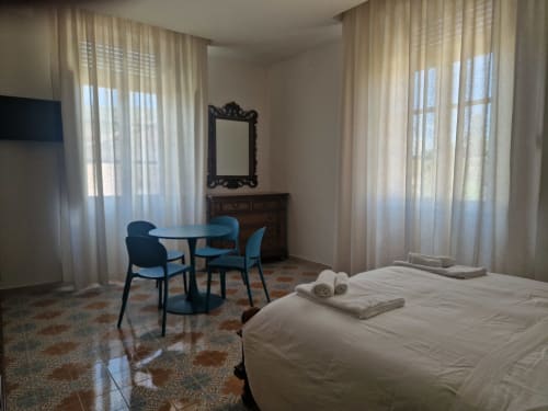 Camera Avventura all'Il 900 Avezzano - letto con asciugamani, zona relax, finestre con vista sul giardino