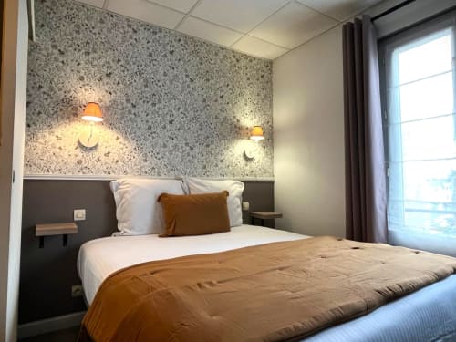 Chambre moderne aux Maisons Delphine avec papier peint à motifs, luminaires suspendus et vue sur la côte à Villers-sur-Mer
