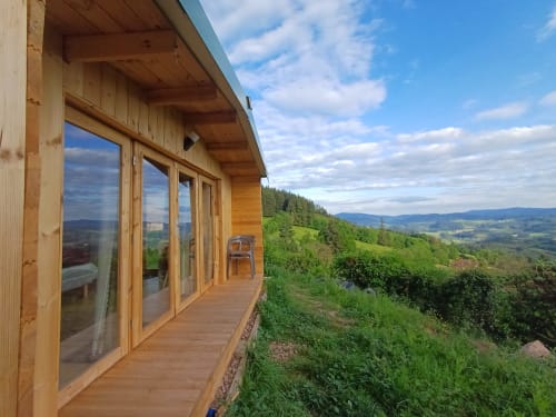 Modern wooden cabin at La Maison de Dun with expansive mountain views over Saint Racho countryside and green valley landscape