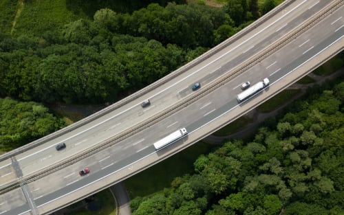 Aerial view of Highway near Lion sur Mer with vehicles and surrounding green forest