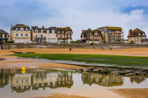Hotel De Lion Sur Mer beachfront with traditional French architecture and sandy shore reflection at Lion sur Mer