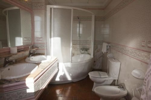 Baño espacioso en Hostal Mar de Frente con doble lavamanos, bañera esquinera, inodoro, bidet y ducha en Los Caños