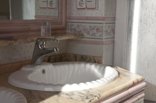 Lavamanos blanco con forma de concha y grifo cromado en el Hostal Mar de Frente, Los Caños de Meca