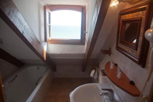 Baño con vista al mar en Hostal Mar de Frente, Los Caños de Meca, con lavamanos, inodoro y espejo