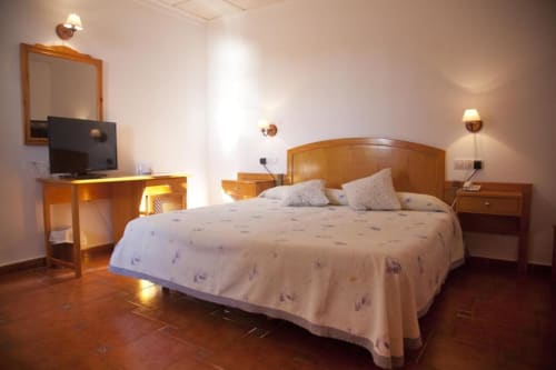 Luminosa habitación doble en Hostal Mar de Frente, Los Caños de Meca, con muebles de madera, TV, vistas al mar y comodidades modernas