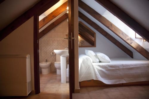 Habitación doble en buhardilla del Hostal Mar de Frente con cama, baño privado, vigas de madera y tragaluces