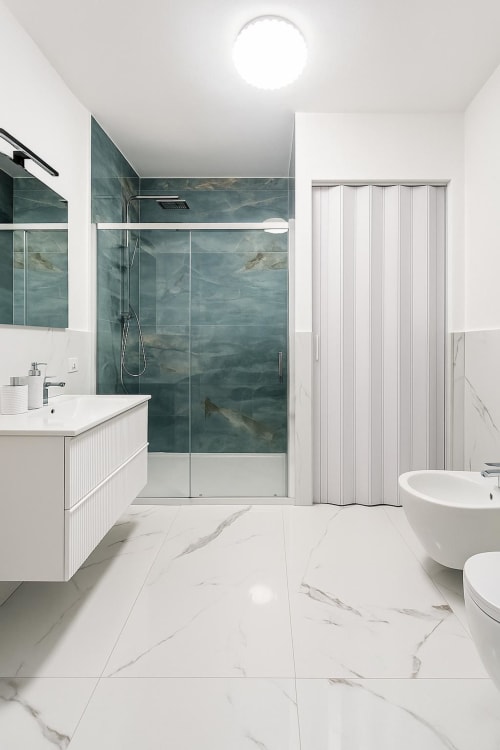 Bagno di lusso moderno nella Luna Suite, Bergamo con doccia in marmo azzurro, pavimento in marmo bianco e vasca indipendente
