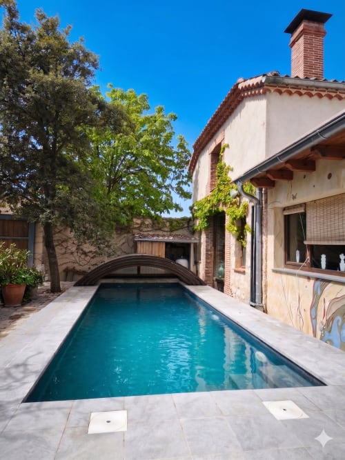 Piscine turquoise avec couverture rétractable du cottage Viento de Ladera à Ségovie, Espagne, architecture en brique et verdure luxuriante