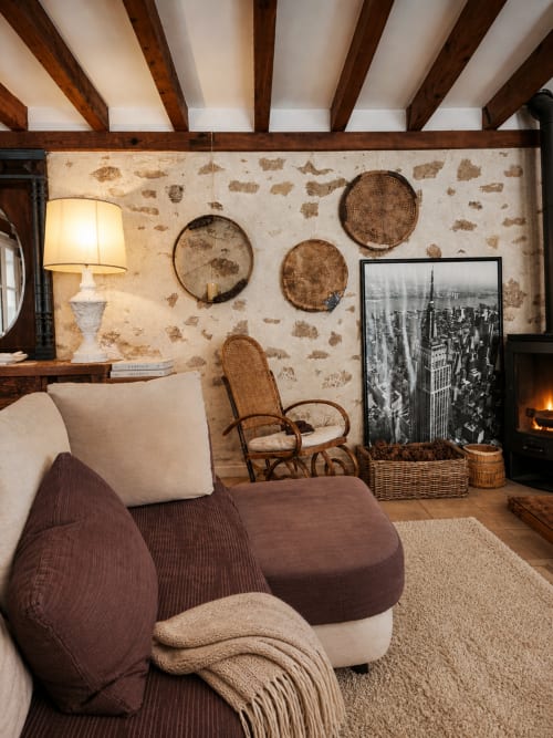 Salon douillet au Viento de Ladera avec poutres rustiques, paniers tressés muraux, foyer et mobilier traditionnel